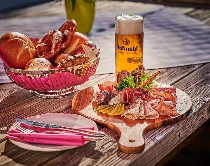 Brozeit im Biergarten des Landhotel Zur Jurahöhe Ein gemütliche Brotzeit im Biergarten.
Hierzu wird ein Brotzeitbrettl mit einem Korb Brezen/Semmeln und einem Bier serviert.